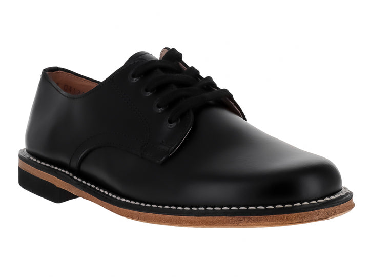 Zapato formal para niño de piel color negro con cordones y suela en tono café.