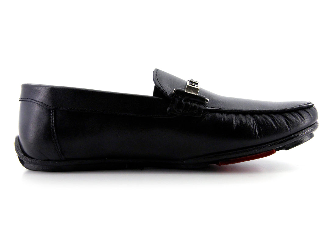 Zapato tipo mocasín de cuero negro con detalle de hebilla metálica y suela roja.