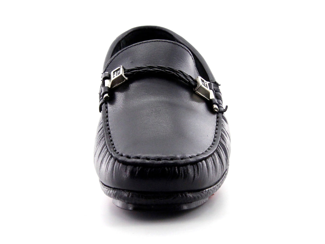 Zapato tipo mocasín de cuero negro con detalle de hebilla metálica y suela roja.