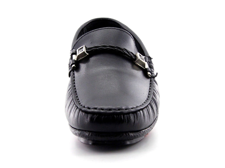 Zapato tipo mocasín de cuero negro con detalle de hebilla metálica y suela roja.