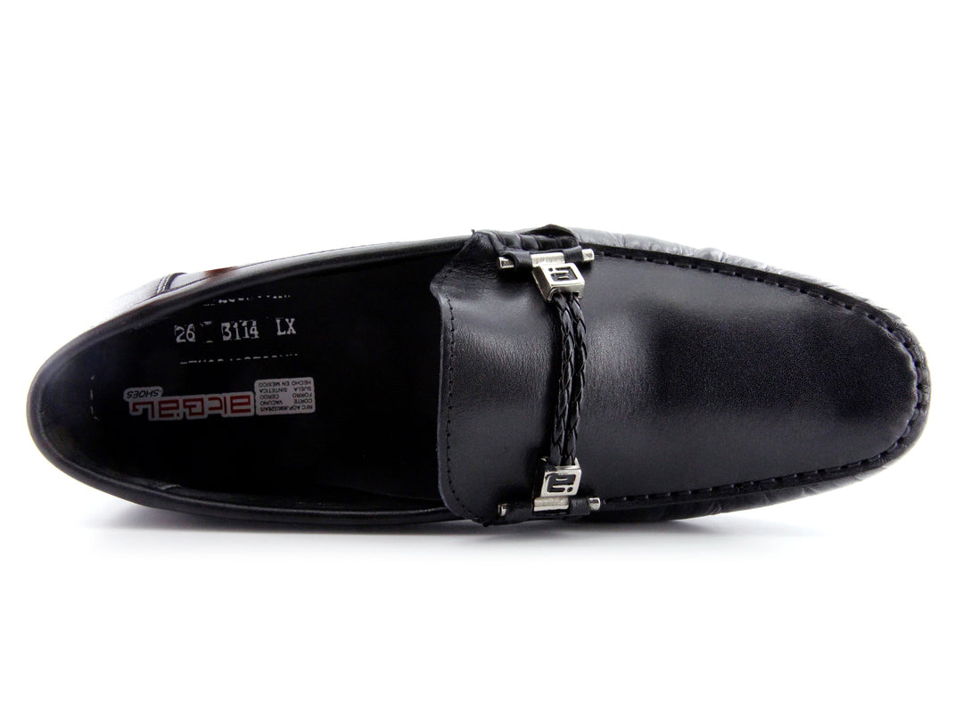 Zapato tipo mocasín de cuero negro con detalle de hebilla metálica y suela roja.