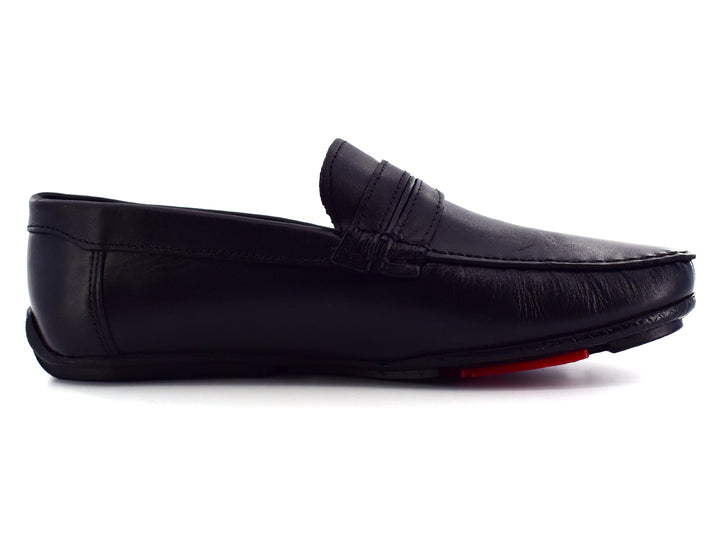 Zapato tipo mocasín de cuero color negro con detalle rojo en la suela, vista lateral.