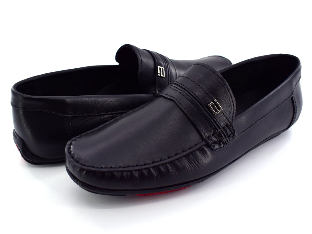 Zapato tipo mocasín de cuero color negro con detalle rojo en la suela, vista lateral.