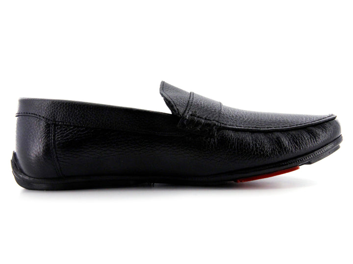 Zapato tipo mocasín de cuero negro con textura rugosa y detalle en la suela color rojo.