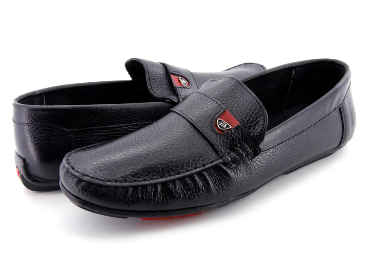 Zapato tipo mocasín de cuero negro con textura rugosa y detalle en la suela color rojo.