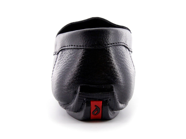 Zapato tipo mocasín de cuero negro con textura rugosa y detalle en la suela color rojo.