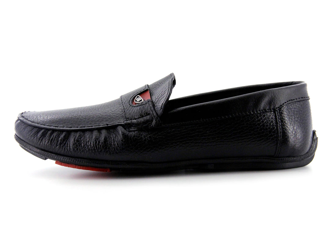 Zapato tipo mocasín de cuero negro con textura rugosa y detalle en la suela color rojo.