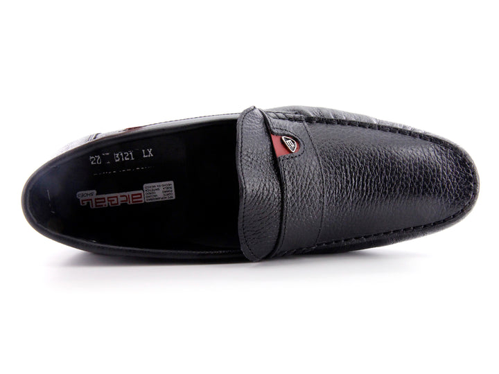 Zapato tipo mocasín de cuero negro con textura rugosa y detalle en la suela color rojo.