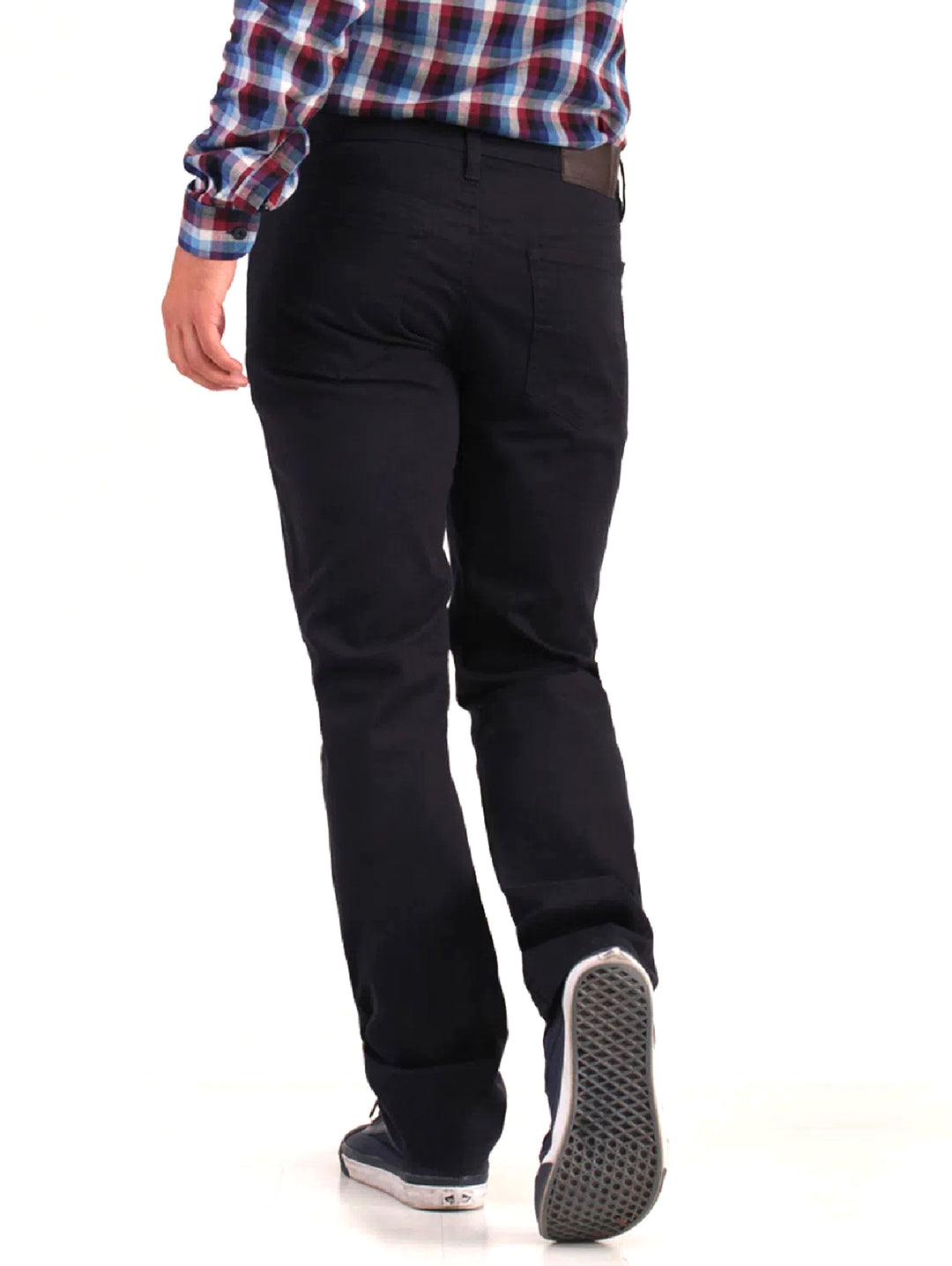 Hombre vistiendo pantalones jeans color marino de corte casual y calzado deportivo.