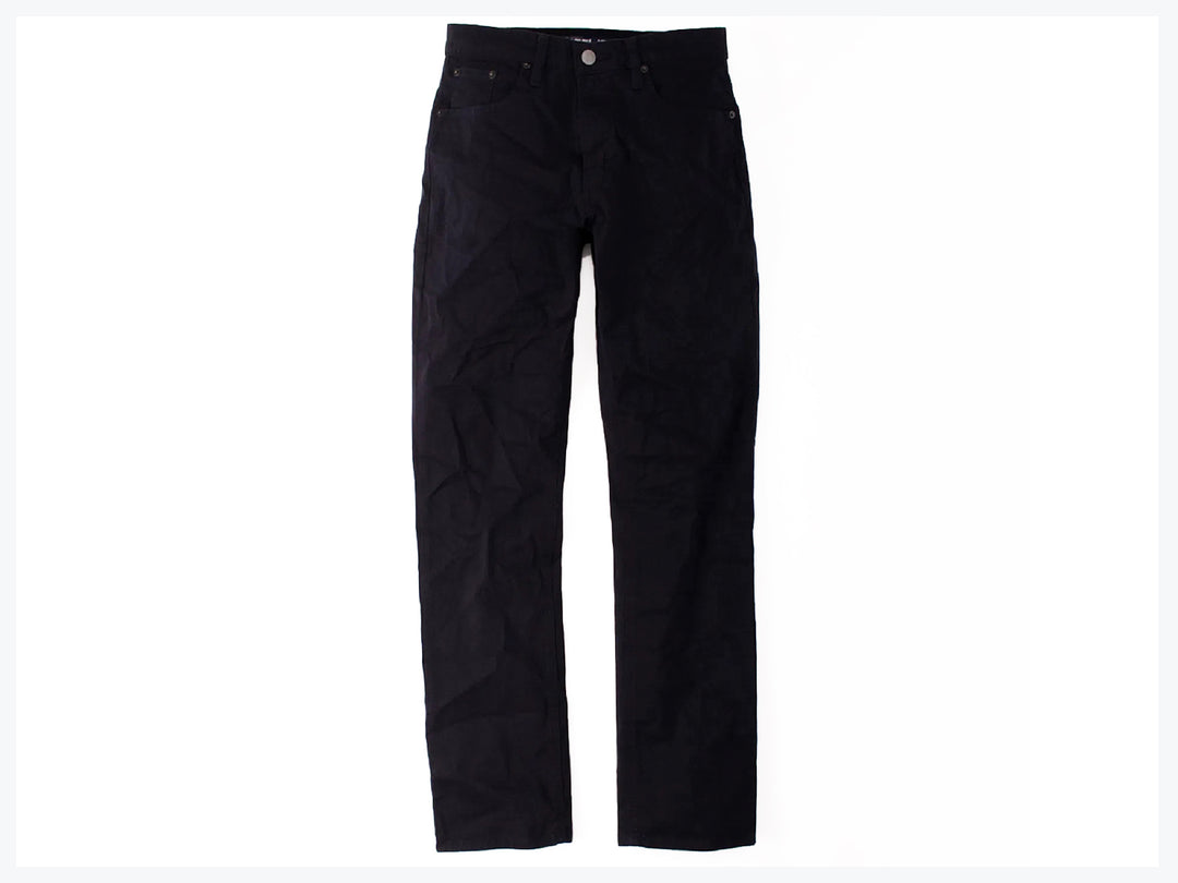 Hombre vistiendo pantalones jeans color marino de corte casual y calzado deportivo.