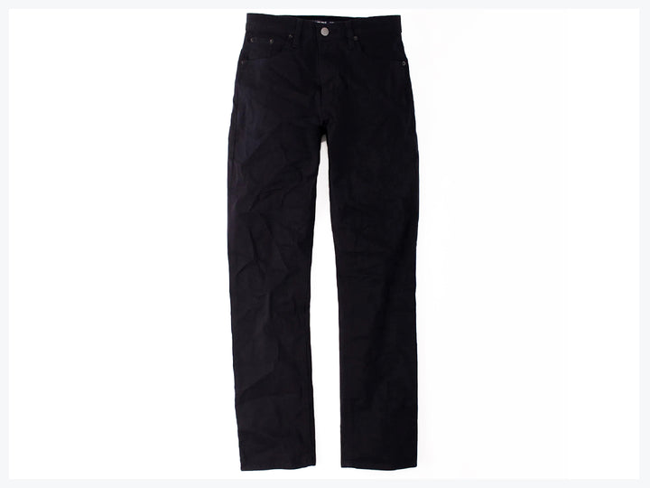 Hombre vistiendo pantalones jeans color marino de corte casual y calzado deportivo.