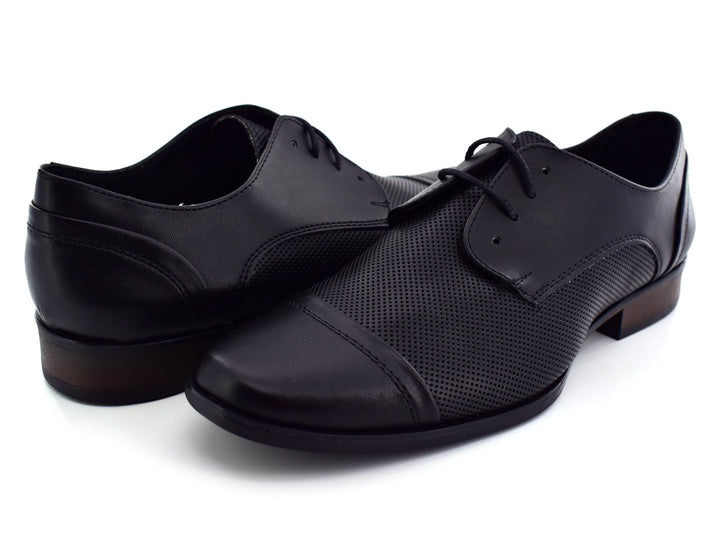 Par de zapatos negros para hombre con cordones y detalles perforados sobre fondo blanco.