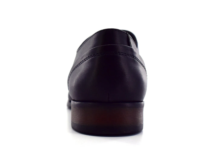 Par de zapatos negros para hombre con cordones y detalles perforados sobre fondo blanco.