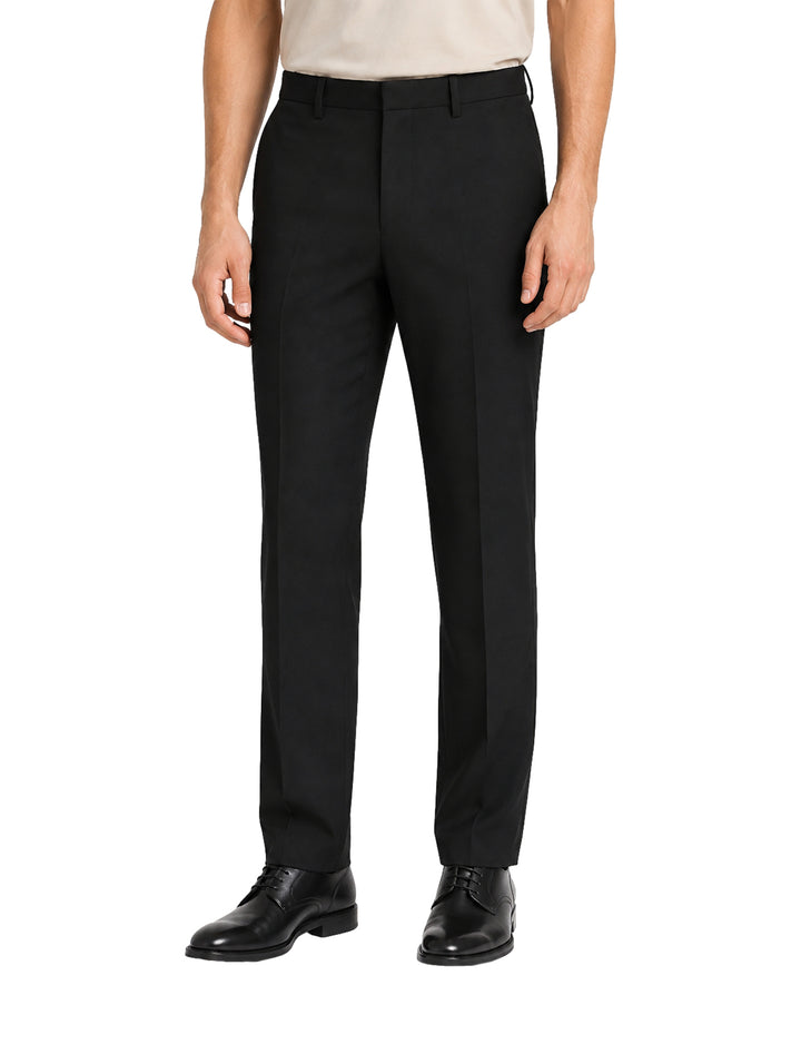 Hombre vistiendo un pantalón formal de color negro, corte recto y zapatos negros.