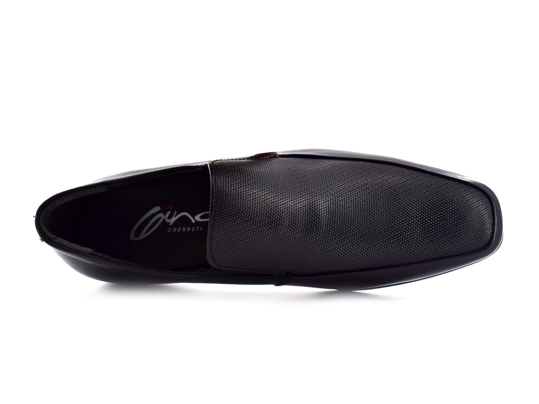 Zapato slip-on color negro para hombre con detalle perforado en la parte superior.