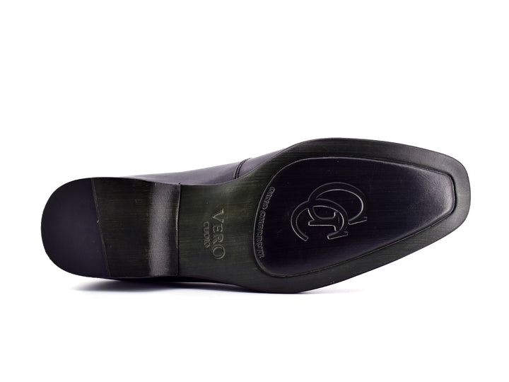 Zapato slip-on color negro para hombre con detalle perforado en la parte superior.