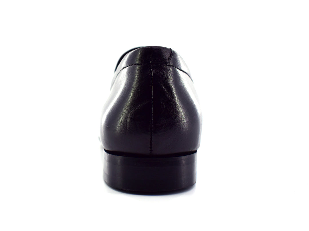 Zapato slip-on color negro para hombre con detalle perforado en la parte superior.