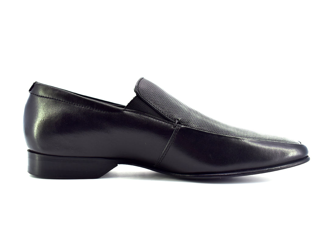 Zapato slip-on color negro para hombre con detalle perforado en la parte superior.