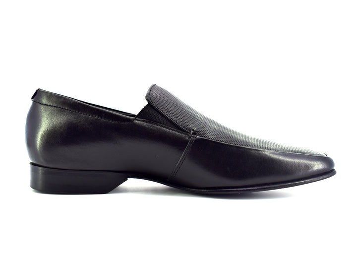 Zapato slip-on color negro para hombre con detalle perforado en la parte superior.