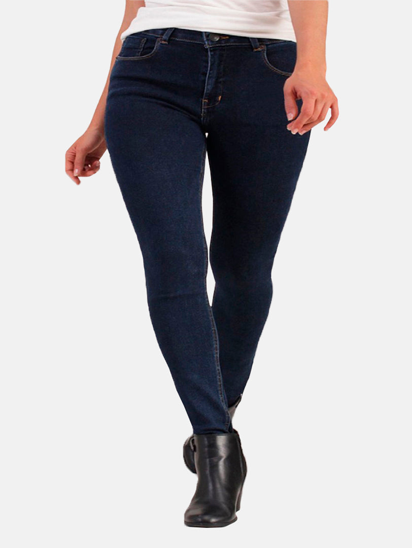 Mujer vistiendo jeans ajustados color azul oscuro con botas negras.