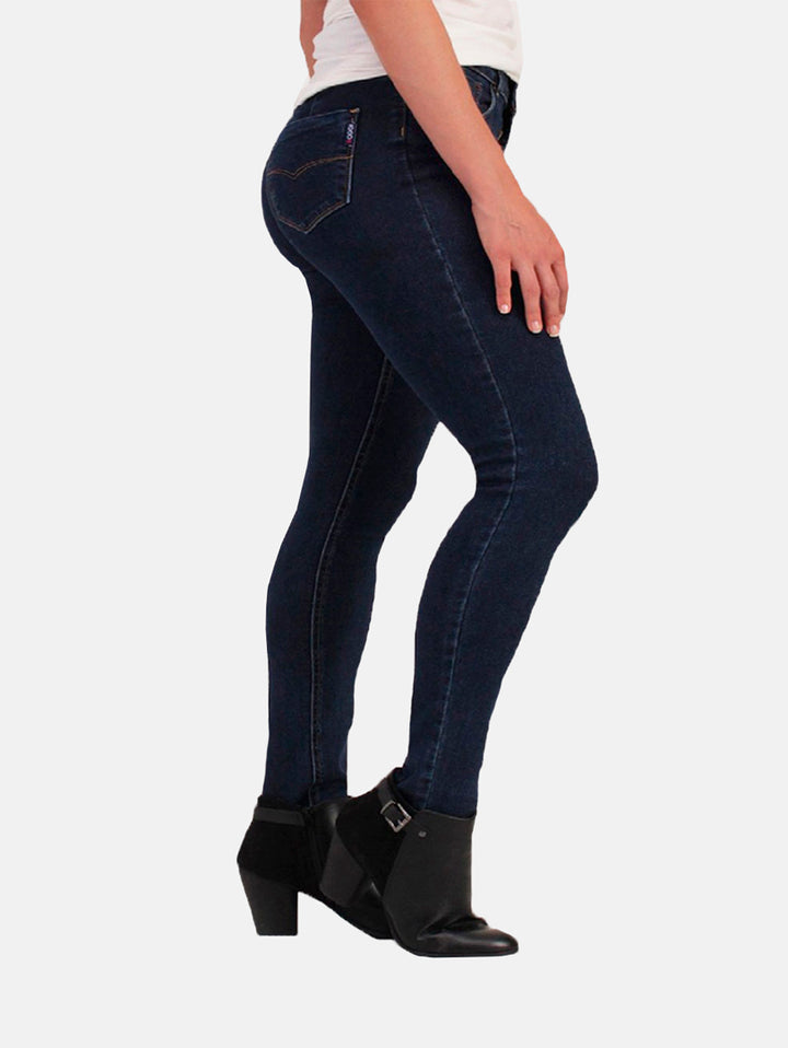 Mujer vistiendo jeans ajustados color azul oscuro con botas negras.