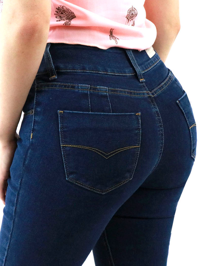 Mujer vistiendo jeans ajustados color azul oscuro con botas negras.