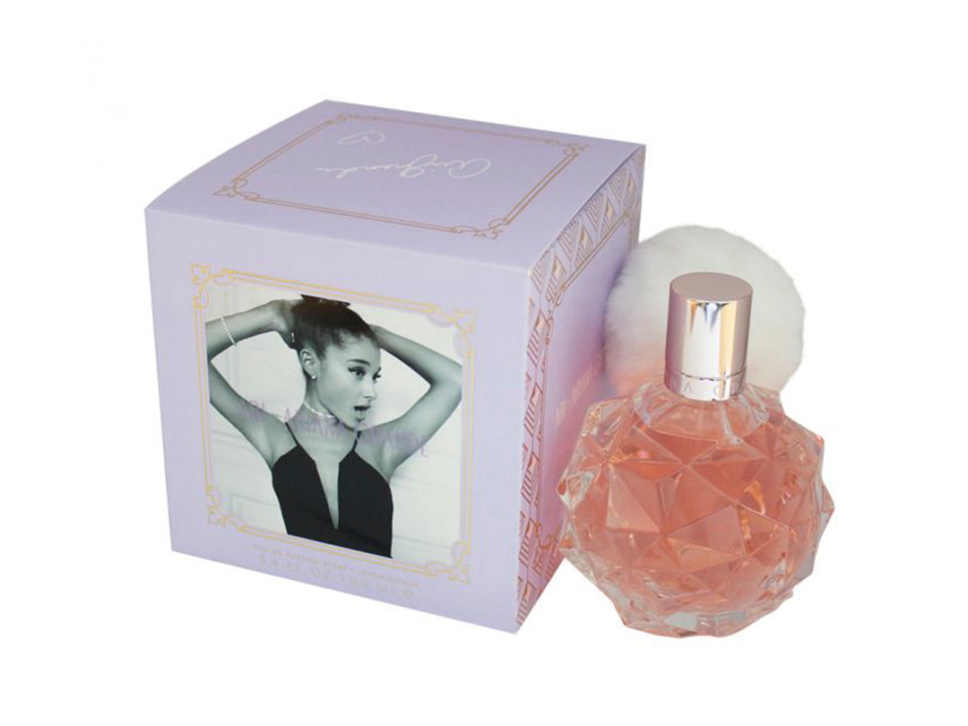 Perfume Ariana Grande Ari con botella de vidrio facetado rosa y caja de color morado claro.