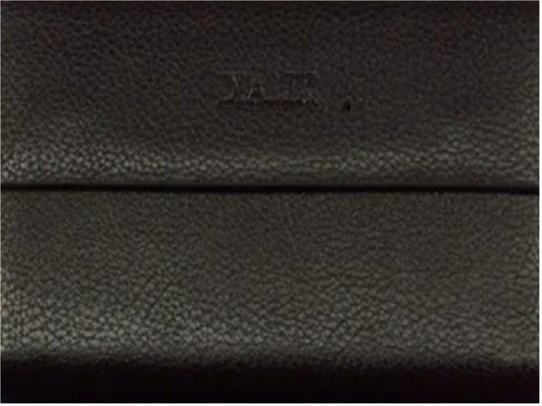 Primer plano de una cartera negra con textura granulada y logotipo grabado.