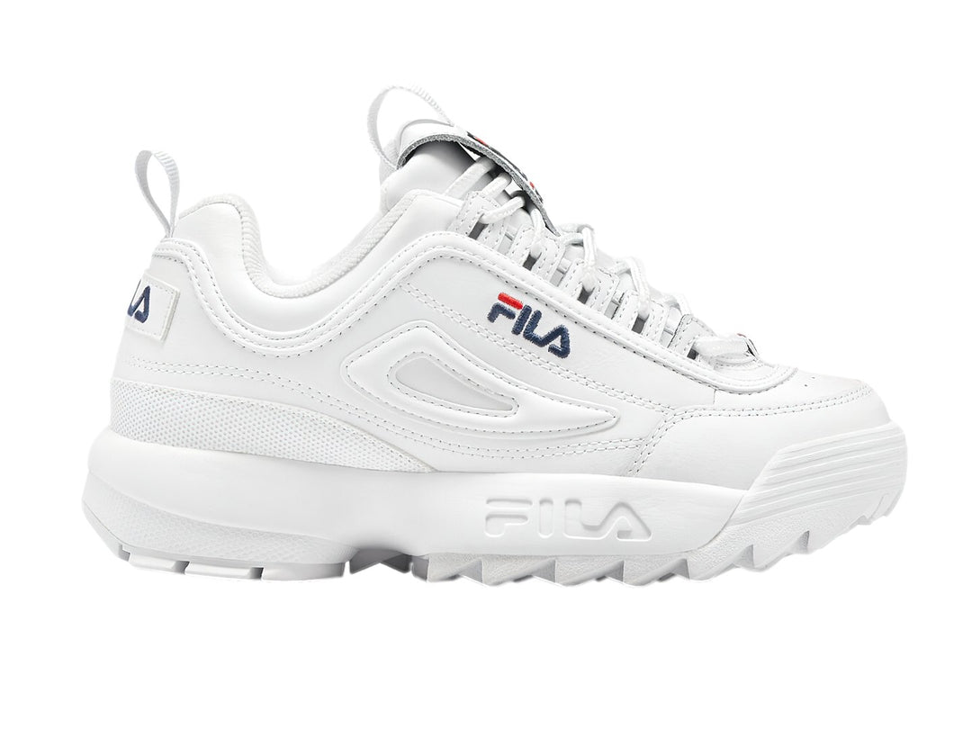 Tenis FILA Disruptor Premium en color blanco con detalles mínimos en azul y rojo, suela gruesa y dentada.