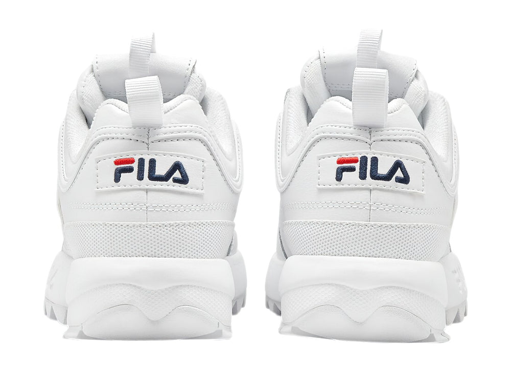 Tenis FILA Disruptor Premium en color blanco con detalles mínimos en azul y rojo, suela gruesa y dentada.