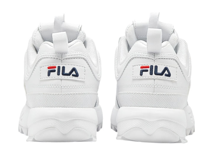 Tenis FILA Disruptor Premium en color blanco con detalles mínimos en azul y rojo, suela gruesa y dentada.
