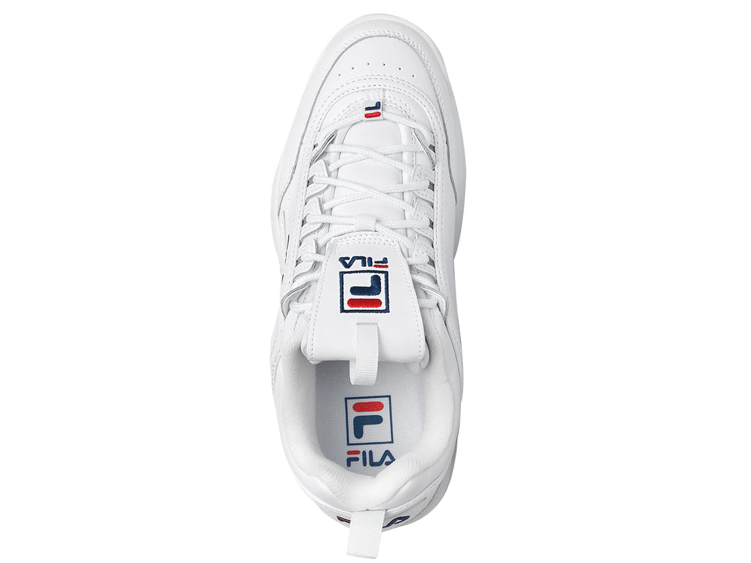 Tenis FILA Disruptor Premium en color blanco con detalles mínimos en azul y rojo, suela gruesa y dentada.