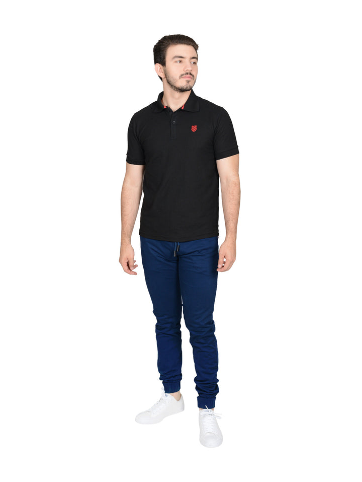 Hombre vistiendo playera polo K-Swiss color negro con detalles rojos.