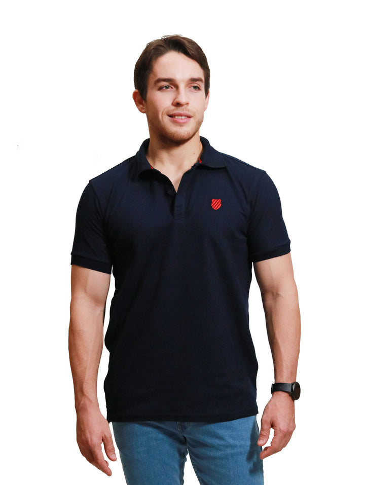 Hombre vistiendo playera polo K-Swiss color marino de manga corta.