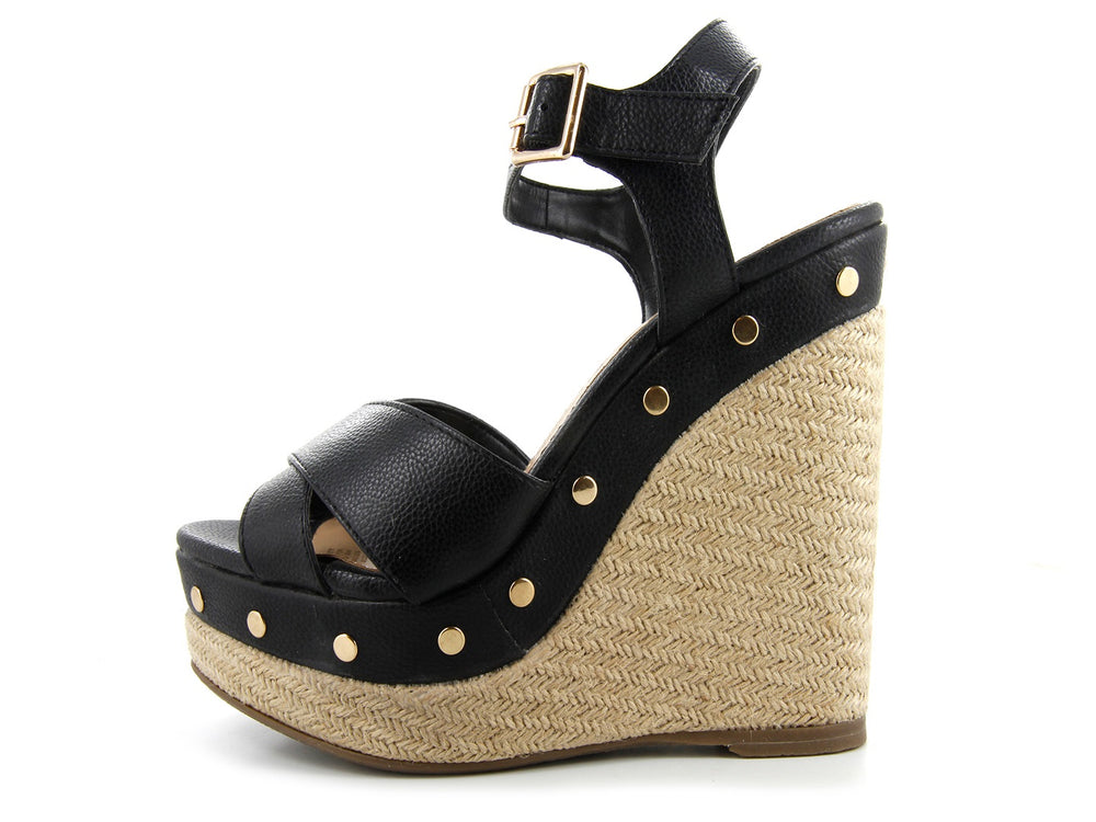 Sandalias negras de plataforma con cuña de yute y remaches dorados.