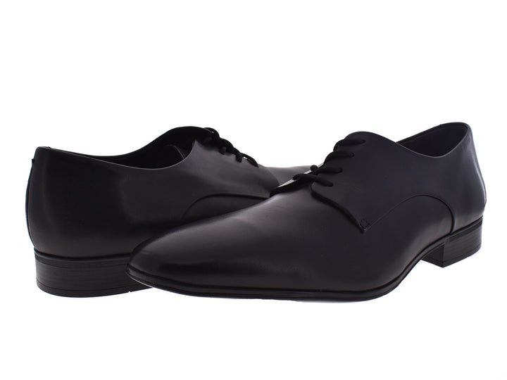 Par de zapatos formales negros de cuero con cordones para hombre sobre fondo blanco.