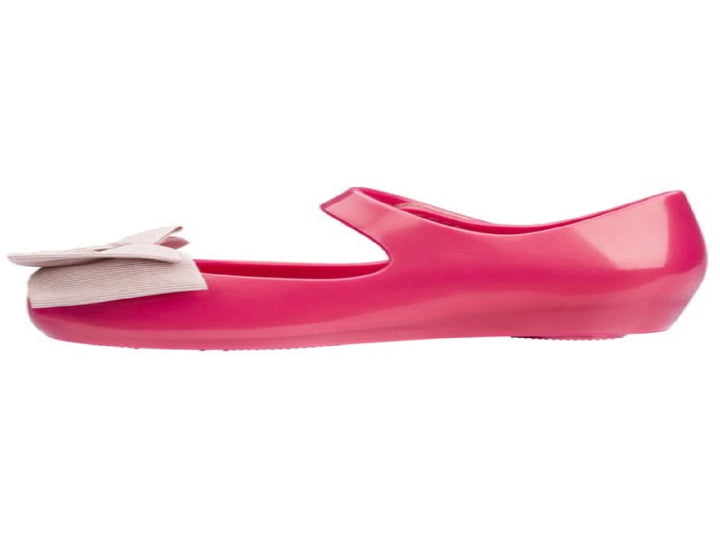 Sandalias infantiles Mini Melissa color rosa oscuro con moño decorativo en la parte frontal.