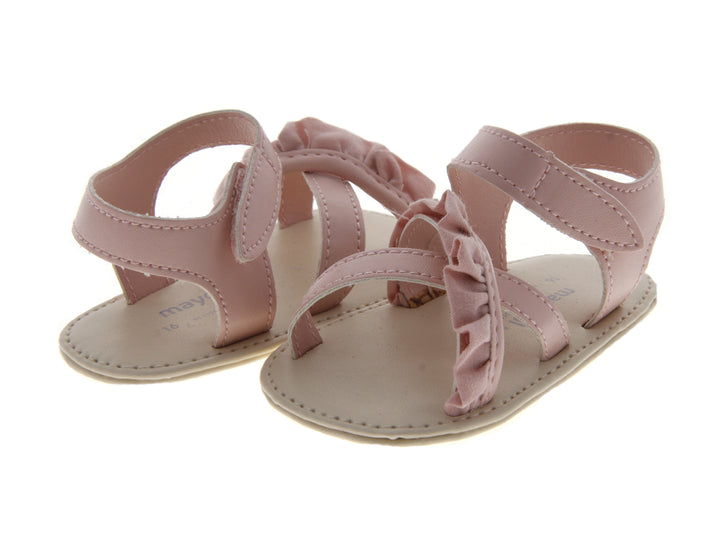 Sandalias color rosa para bebé con detalles de volantes y correas ajustables.