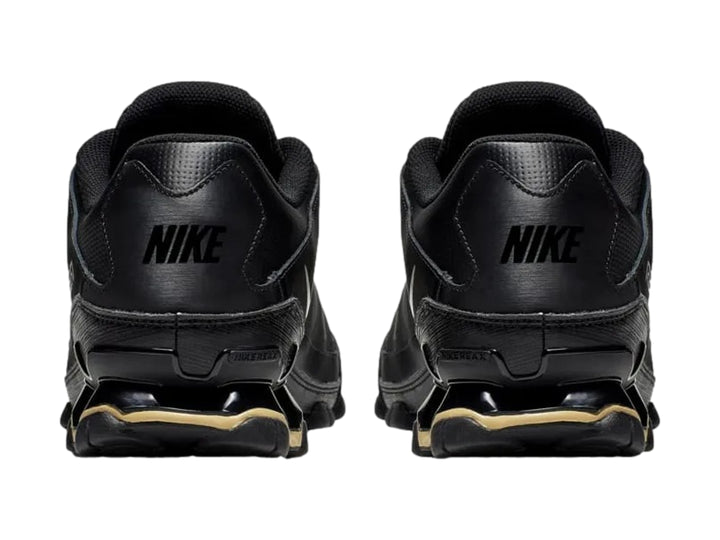 Tenis Nike Reax 8 TR Mesh en color negro con detalles dorados en la suela, diseño deportivo y malla transpirable.
