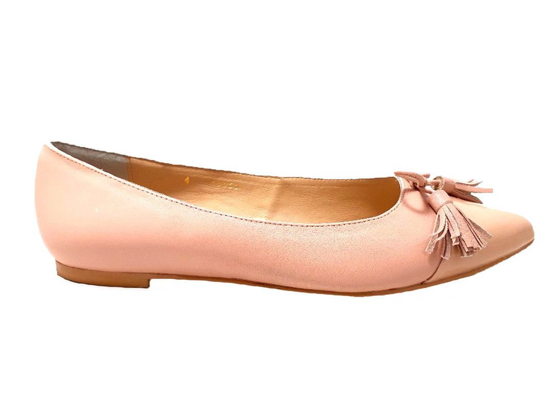 Zapato plano color rosa palo con adorno de borlas en la parte frontal.