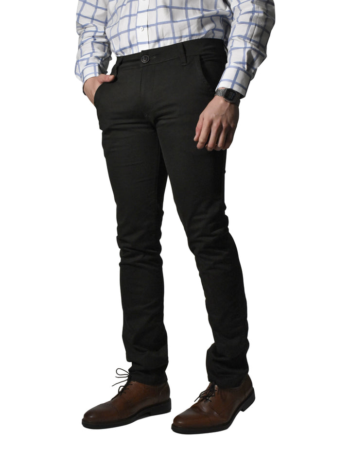 Hombre vistiendo un pantalón negro de corte recto con zapatos cafés y camisa a cuadros.