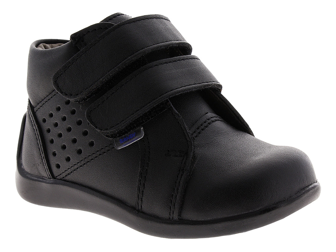 Zapato infantil color negro con cierre de velcro y detalles perforados.