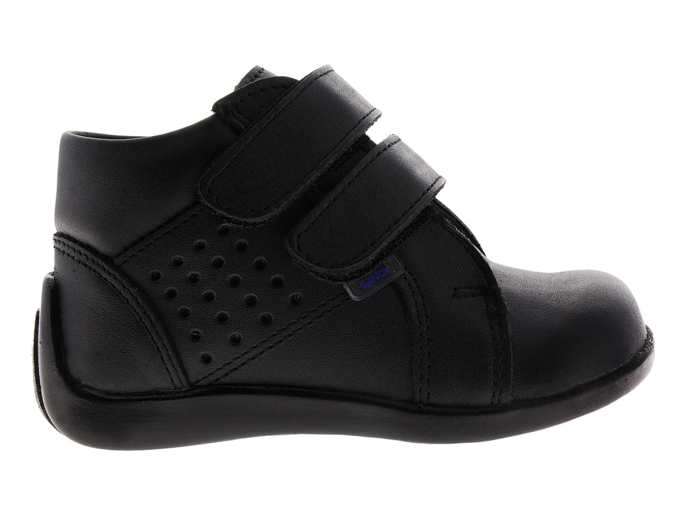 Zapato infantil color negro con cierre de velcro y detalles perforados.
