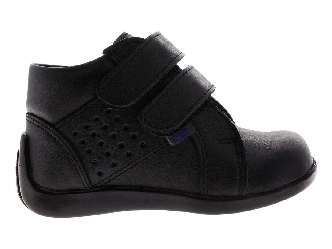 Zapato infantil color negro con cierre de velcro y detalles perforados.