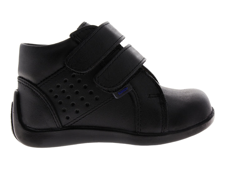 Zapato infantil color negro con cierre de velcro y detalles perforados.