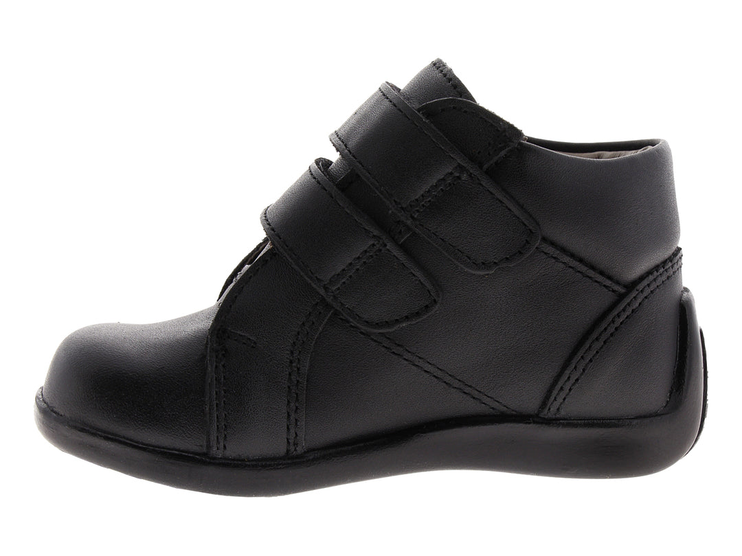 Zapato infantil color negro con cierre de velcro y detalles perforados.