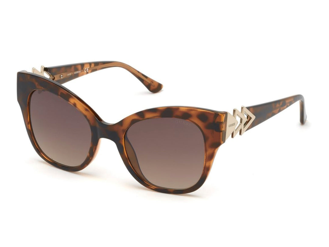 Lentes de sol Guess con armazón color carey y detalles metálicos dorados en los laterales.