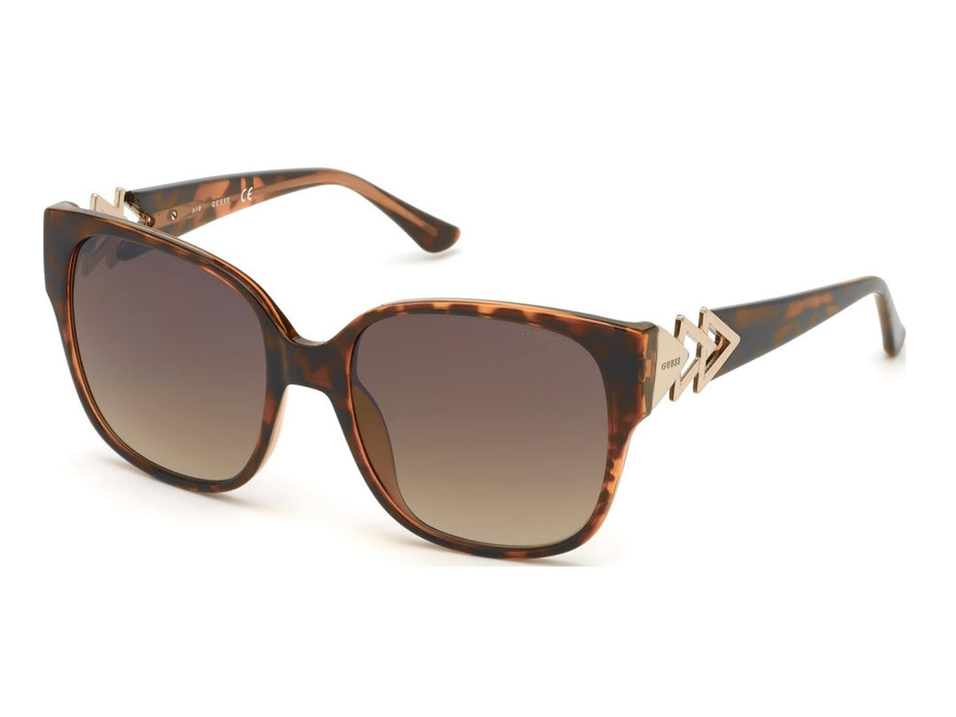 Lentes de sol Guess color carey con detalles dorados en las varillas y micas degradadas.