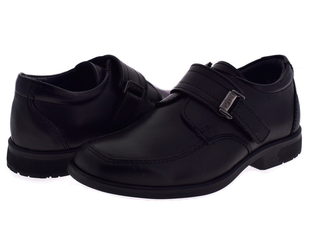 Par de zapatos negros formales para niño con hebilla plateada sobre fondo blanco.