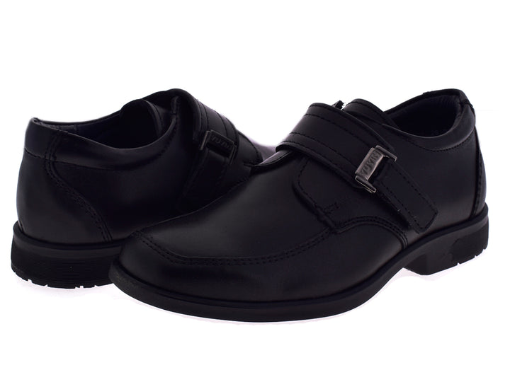 Par de zapatos negros formales para niño con hebilla plateada sobre fondo blanco.